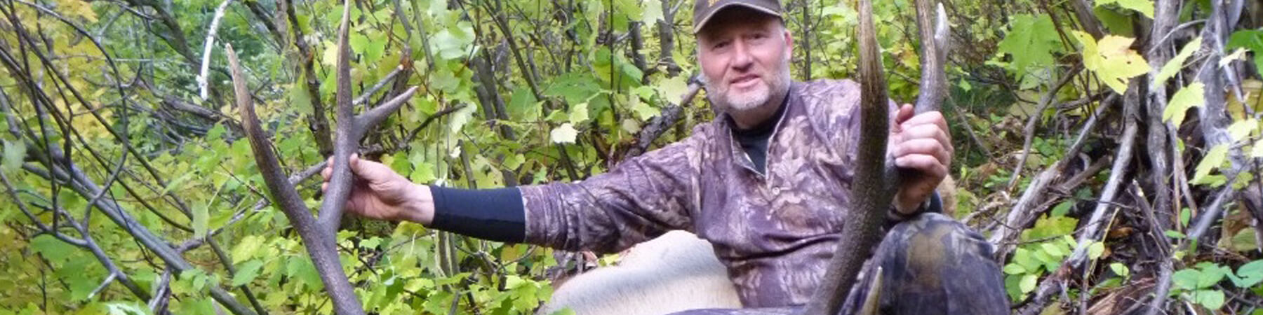 Man posing behind Elk rack