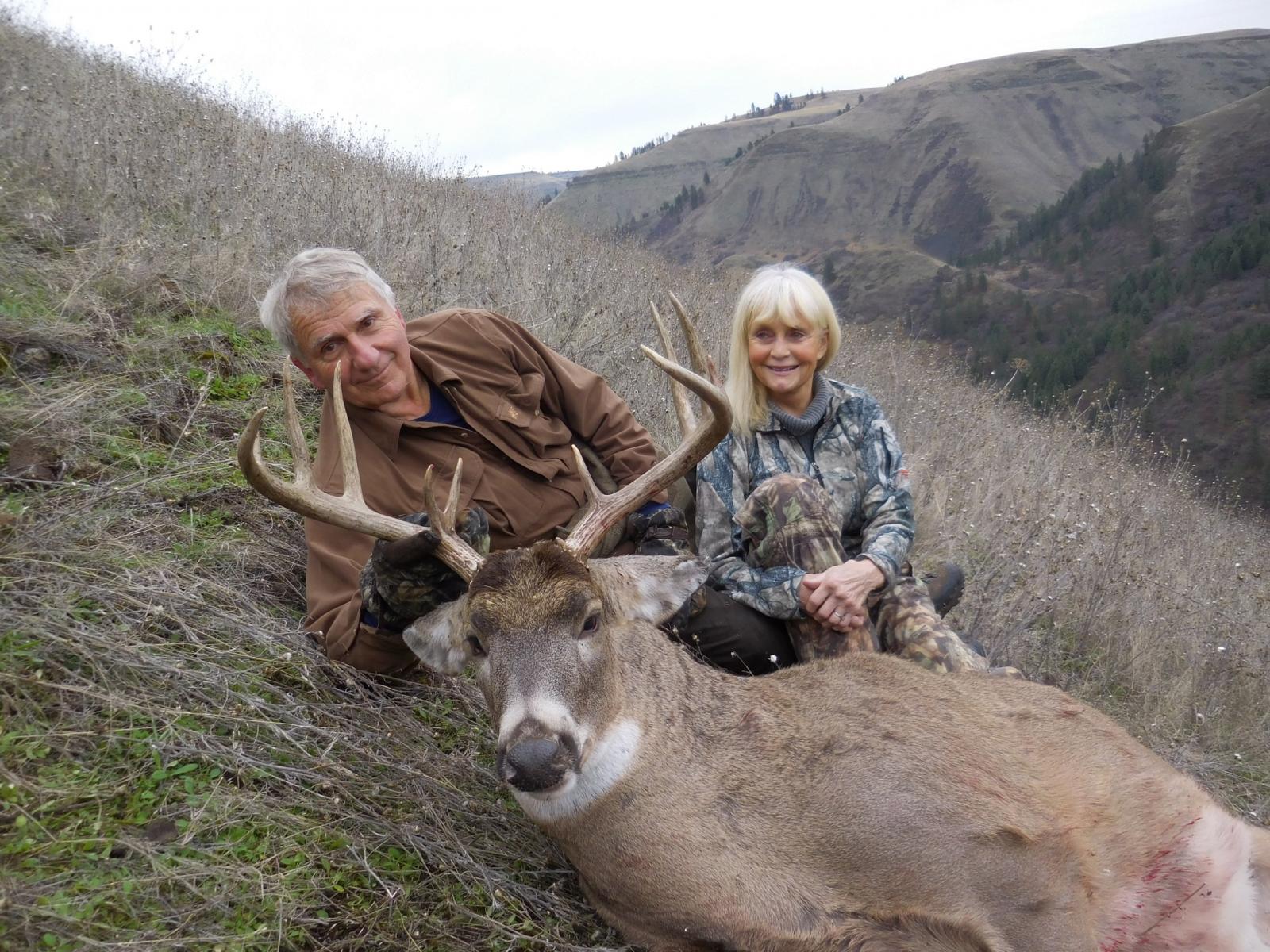 Man and woman posing with mule deer trophy