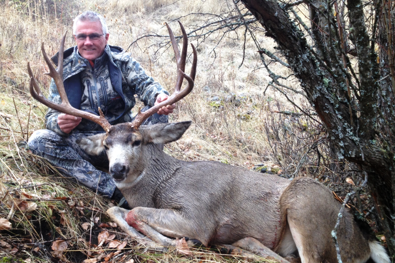 Man posing with mule deer trophy