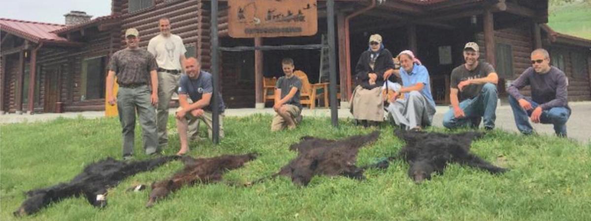 Hunters posing next to their bear trophies